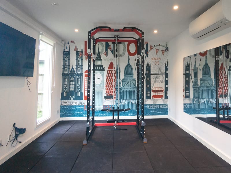 Home gym after — power rack on rubber matting