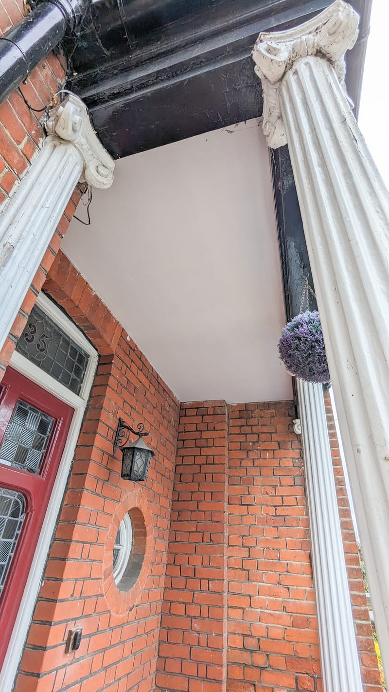 Victorian porch ceiling after — fresh paint, period features preserved