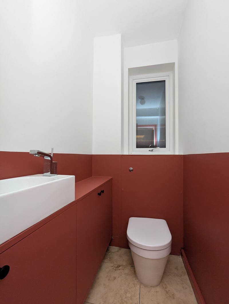 Downstairs WC after — full finished room with travertine floor